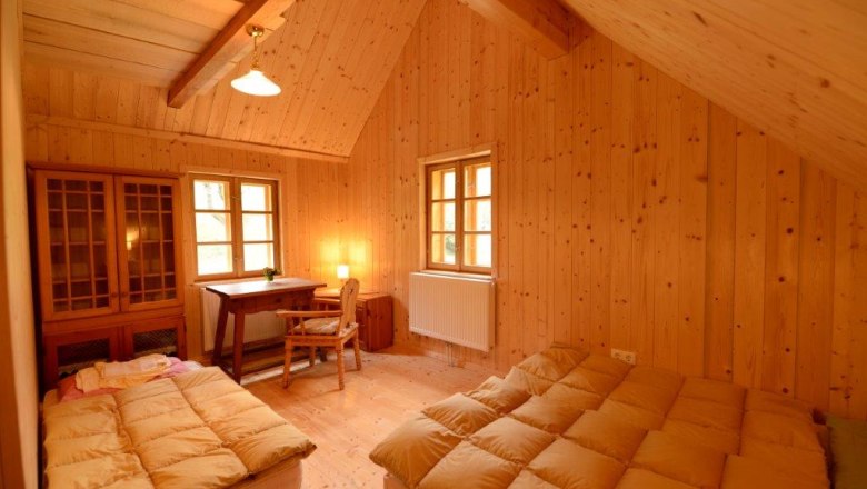 Double room Johanneshaus, © Martina Heilingsetzer Wood-paneled room with two beds, desk and chair.