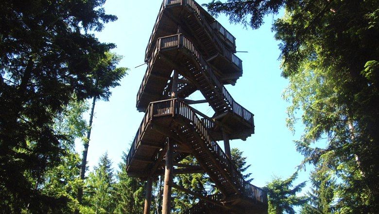 Aubergwarte, © Aubergwarte Wooden lookout tower in the forest with blue sky.