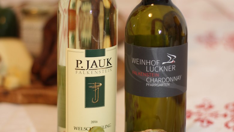 Selection of wines, © Josef Popp Two bottles of wine and a bunch of green grapes on a table.