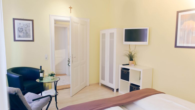 Apartment & guest room "Vino Verde", © Fam. Willmann Bright guest room with bed, armchair, table, wardrobe and TV.