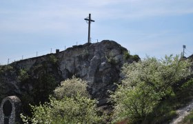 Kreuzberg Kleinschweinbarth, © Kreuzberg Kleinschweinbarth A cross on a hill with blossoming trees in the foreground.
