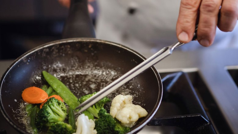 Award-winning cuisine on the Moststraße, © Niederösterreich Werbung/Daniela Führer Cook stirs vegetables in a pan.