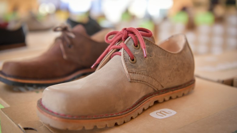 gea_03, © Waldviertel Tourismus, Robert Herbst Close-up of a brown leather shoe with red laces on a cardboard box.