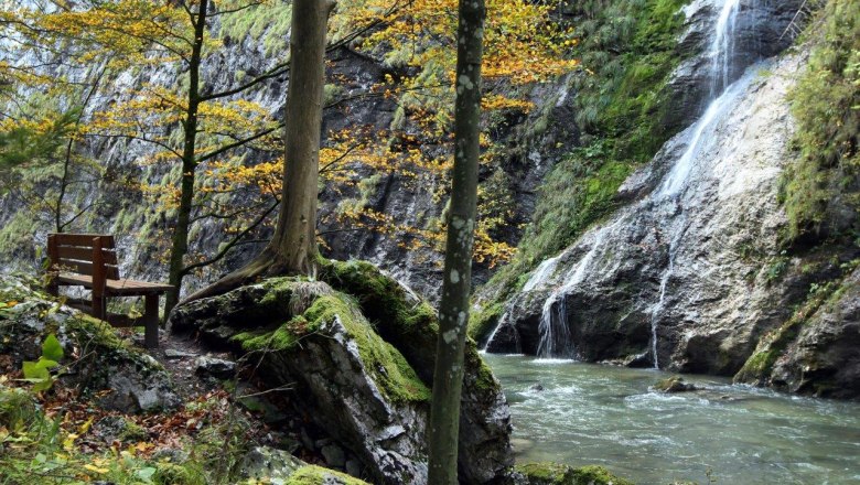 Ötscher Tormäuer Nature Park, © Mostviertel Tourismus, weinfranz.at Bench by the river in the Ötscher Tormäuer Nature Park with waterfall and autumnal trees.