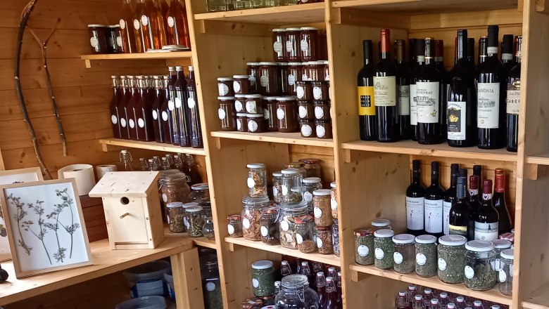 Natural History Witch Garden Shop, © "Natur im Garten" Shelves with bottles, glasses and wine in a wooden store.