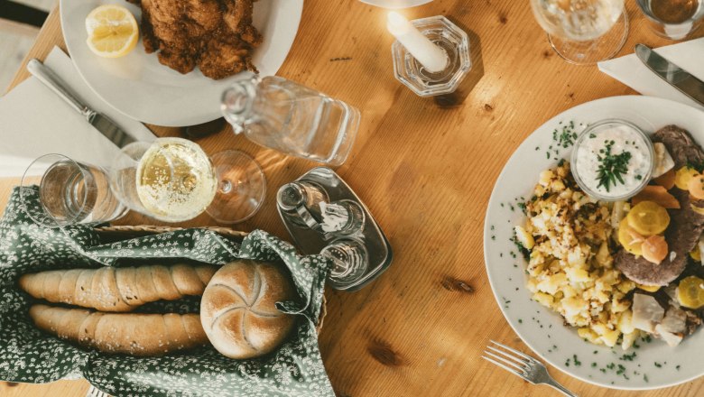 We serve pub classics, © Niederösterreich Werbung/Julius Hirtzberger Table set with schnitzel, potato salad and drinks.