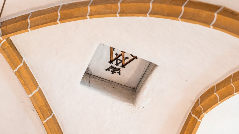 Interior view of a vault with brick arches and a decorative element in the center.