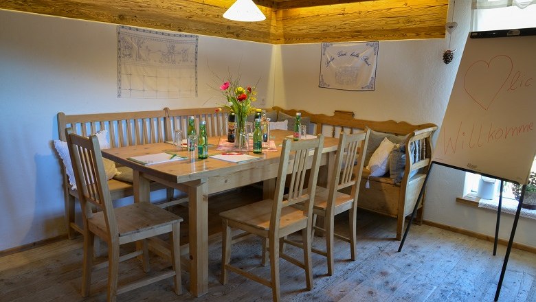 Cozy seminar room with wooden table, chairs and flipchart.