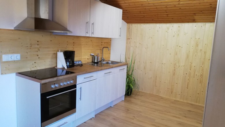 Modern kitchen in a loft with wood paneling and appliances.