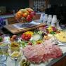 A rich breakfast buffet with cold cuts, cheese, fruit, vegetables and yogurt.