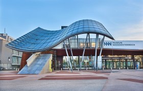 Entrance to the Museum Niederösterreich with modern architecture and curved glass roof.
