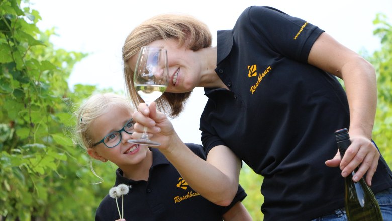 Woman and child in the vineyard with wine glass and dandelion.