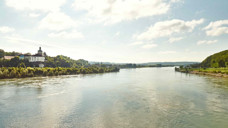 River landscape with buildings on the bank and cloudy sky.