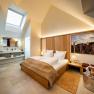 Modern hotel room with skylight, double bed and stylish furnishings.
