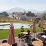 Terrace with pool, parasols and views of vineyards and hills.
