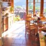 Interior of a sunny conservatory with wooden furniture and a view of the countryside.