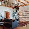 Spiral staircase up to the sleeping area, cozy couch in the foreground