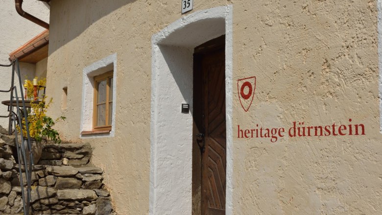 Entrance to a historic building with the inscription 'heritage dürnstein'.