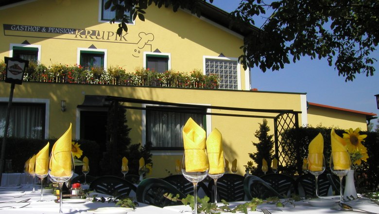 Exterior view of the Krupik inn with a laid table in the foreground.