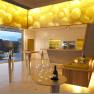 Modern tasting room in a winery with yellow ceiling lighting and glass walls.