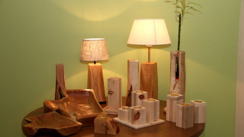 Wooden handicrafts with lamps and candlesticks on a table.