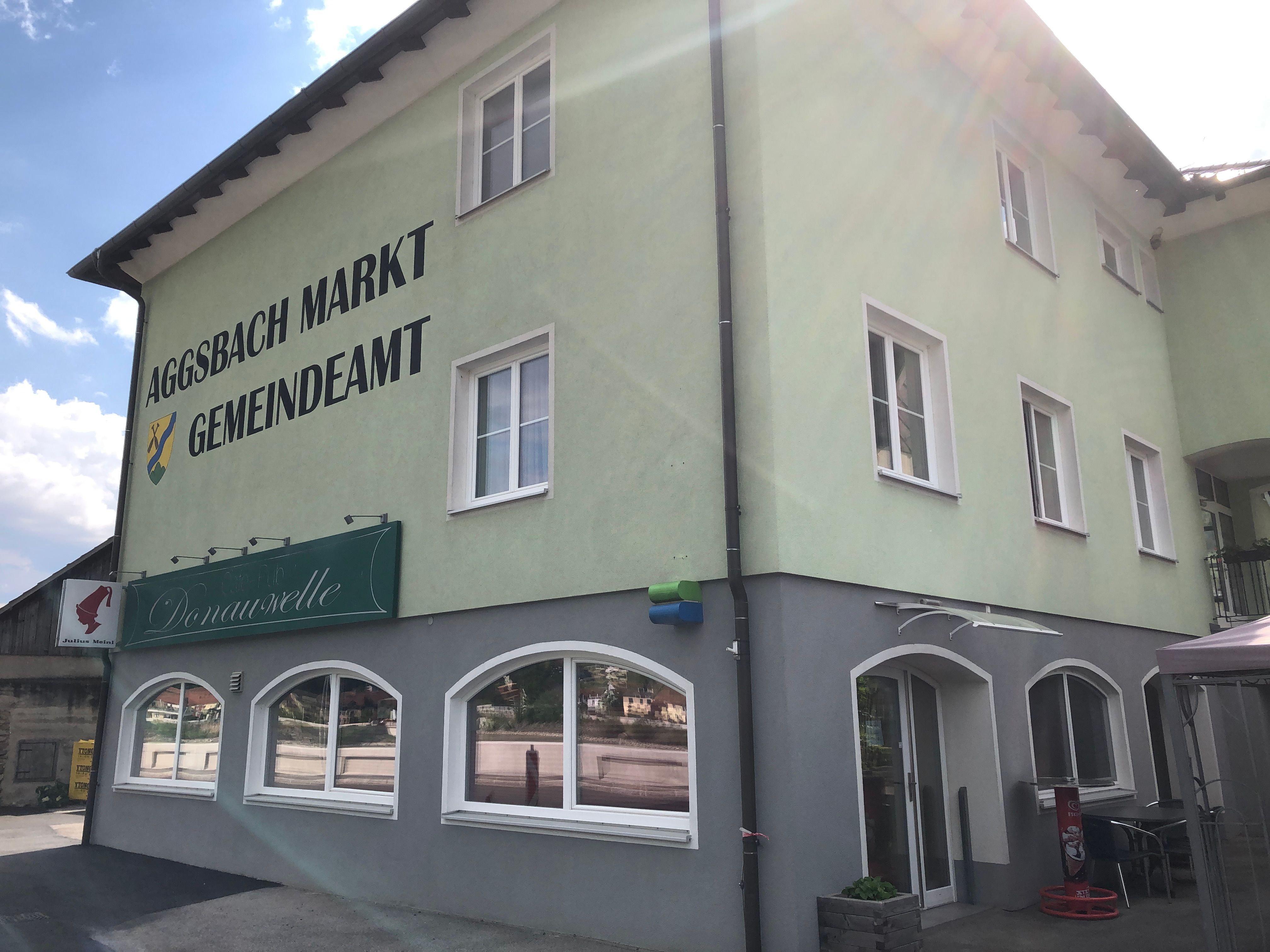 Green building with the inscription 'Aggsbach Markt Gemeindeamt' and Café Donauwelle.
