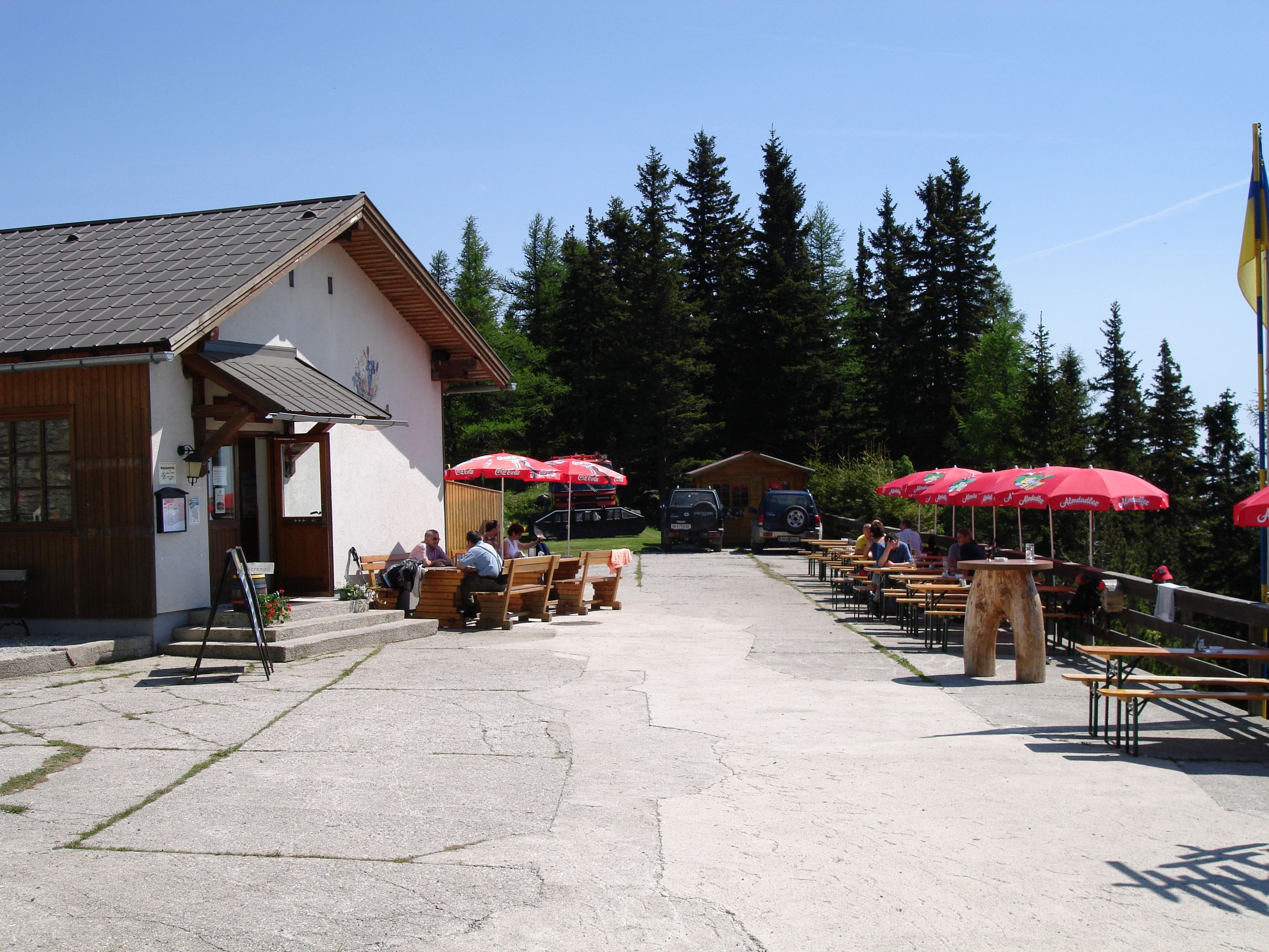 Outdoor area of the Pollereshütte with seating and parasols.