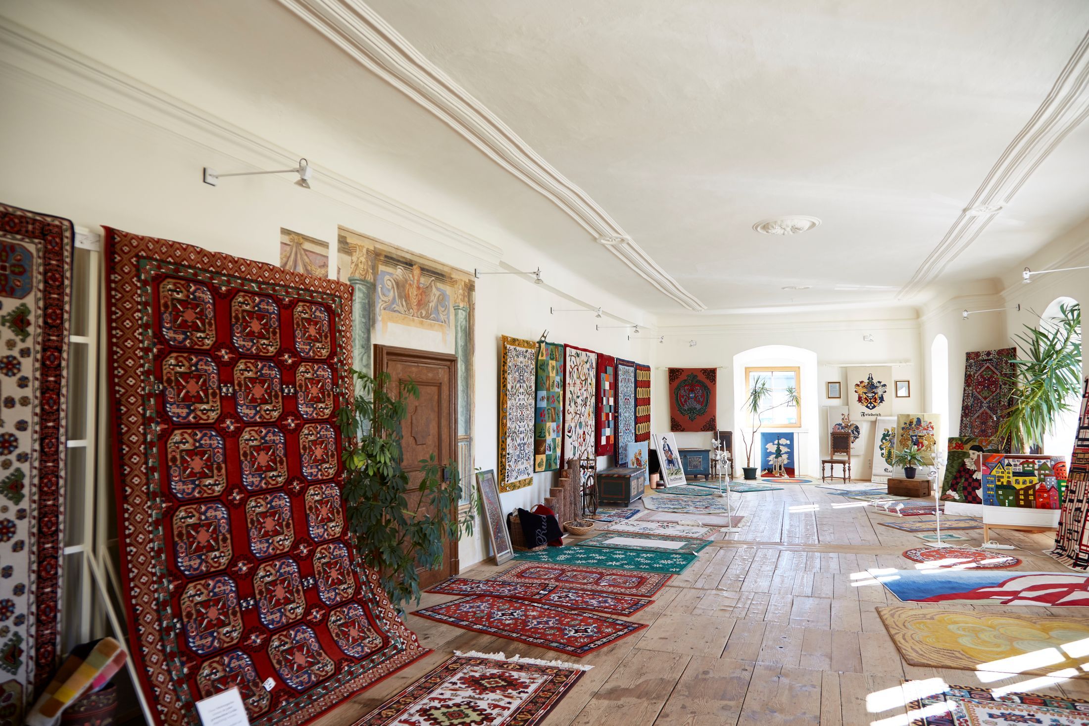 A room in Groß Siegharts Castle with colorful carpets on the walls and floor.