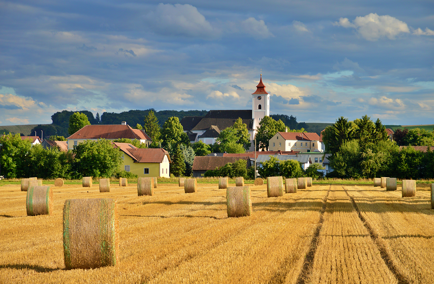 Landscape with straw bales and church in Michelhausen.