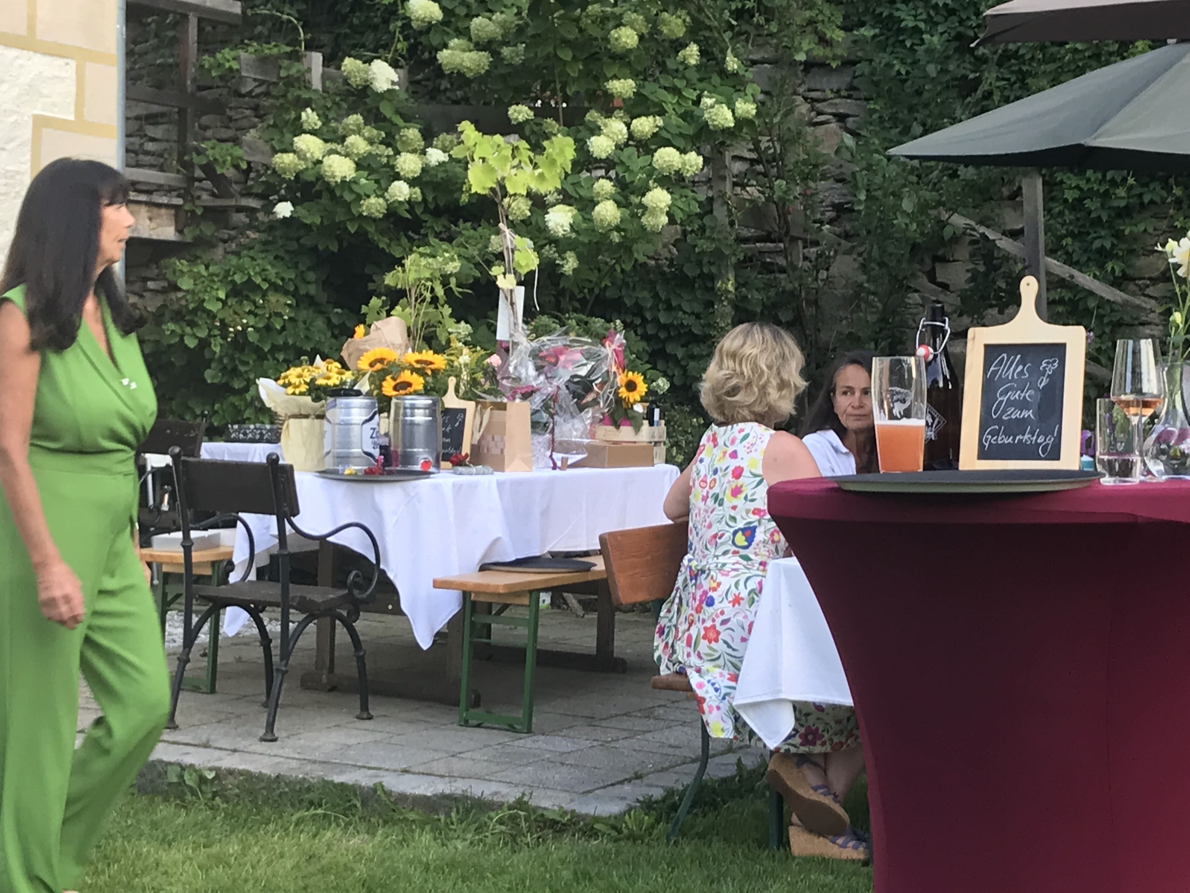 Garden party with decorated tables, flowers and drinks.