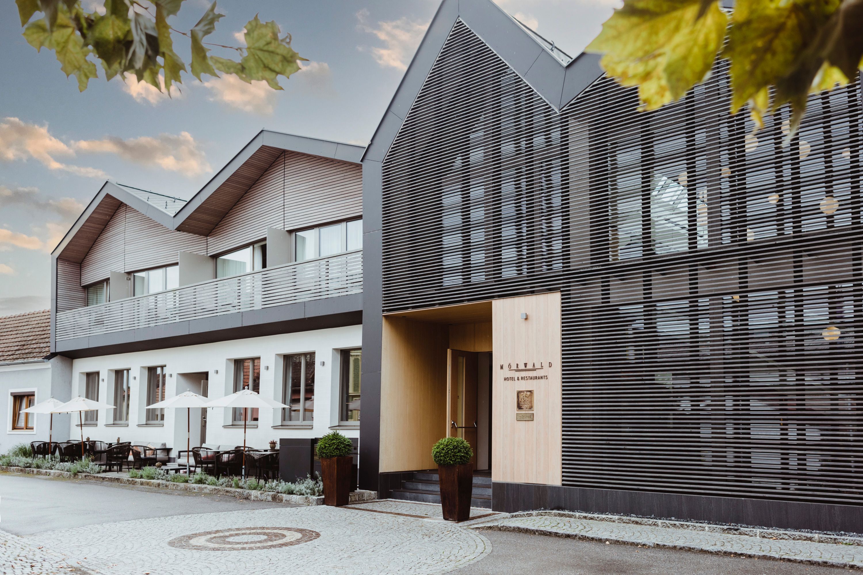 Modern hotel building with terrace and stylish façade.