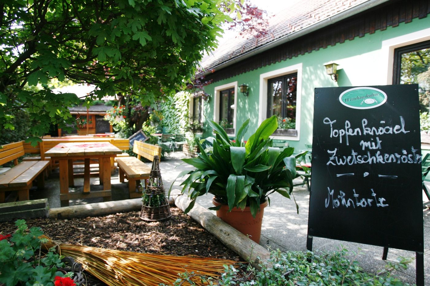 Cozy guest garden with wooden benches and table at Wirtshaus Bonka, Wienerwald.