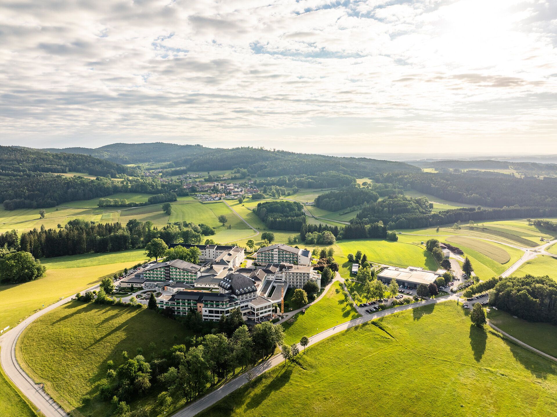 Aerial view of the Harbach Moor Spa in the Waldviertel region, surrounded by green meadows, fields, and wooded hills.