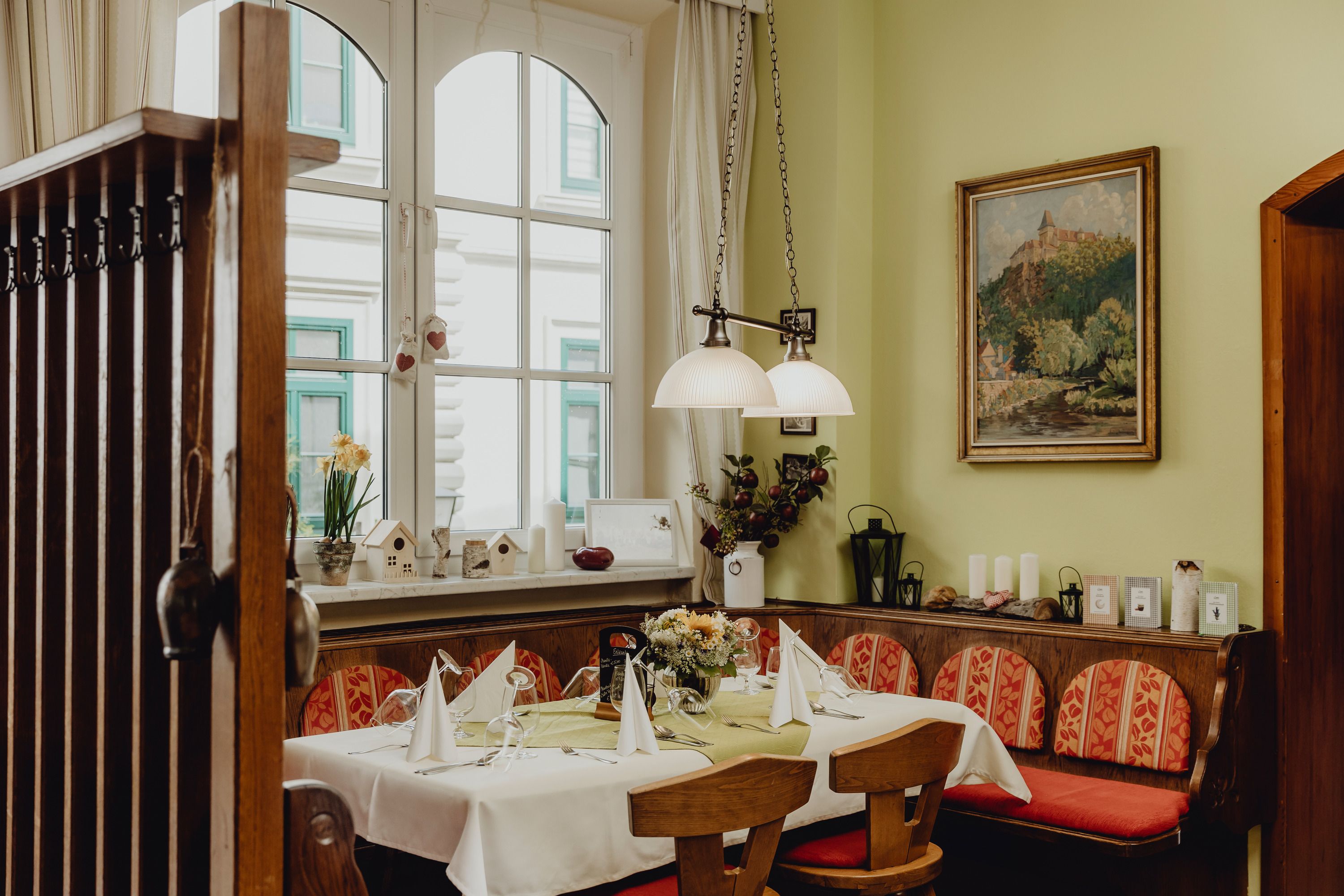 Cozy dining room with table setting, wooden furniture and decorations.