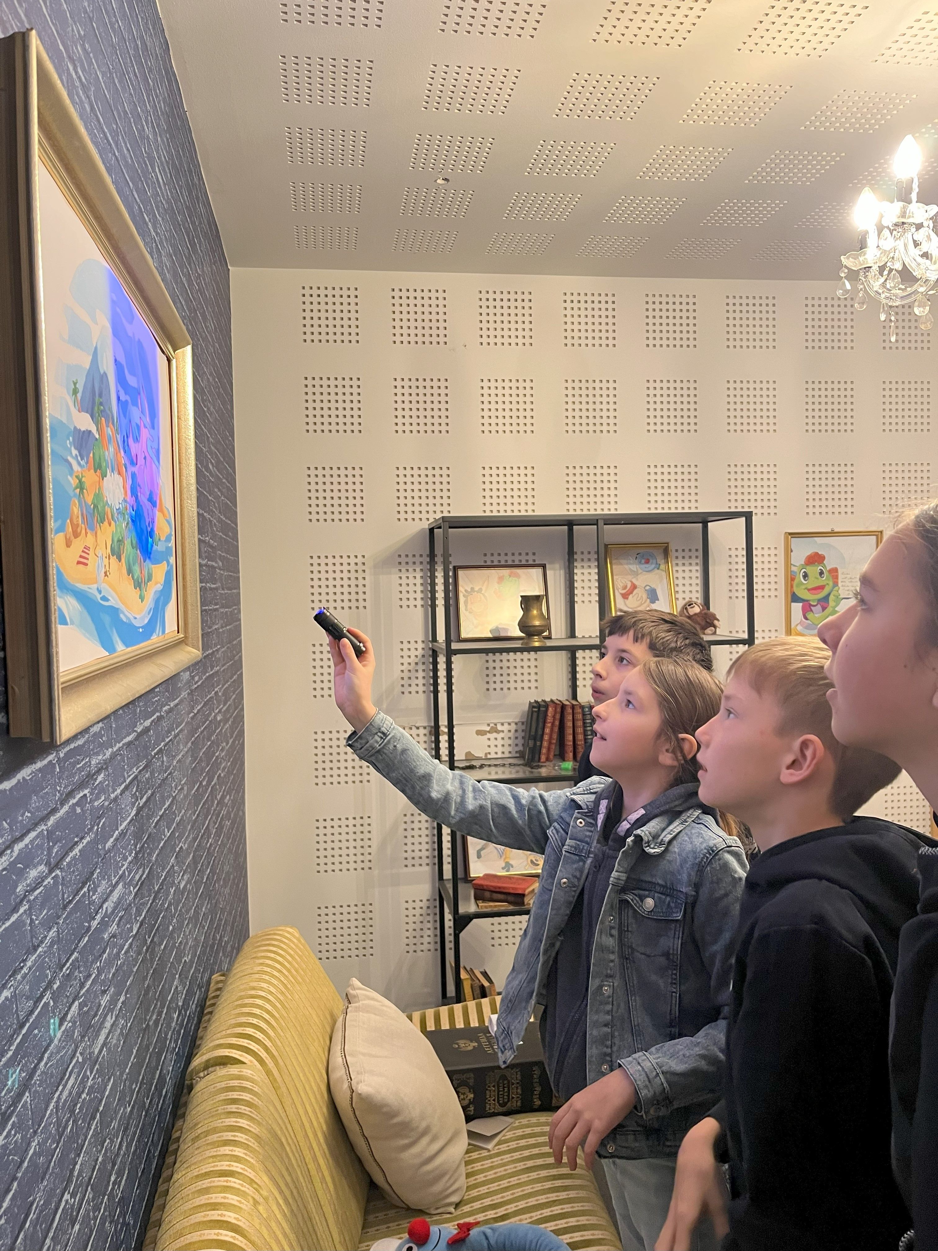 Children illuminate a picture with blue light to decipher a puzzle 