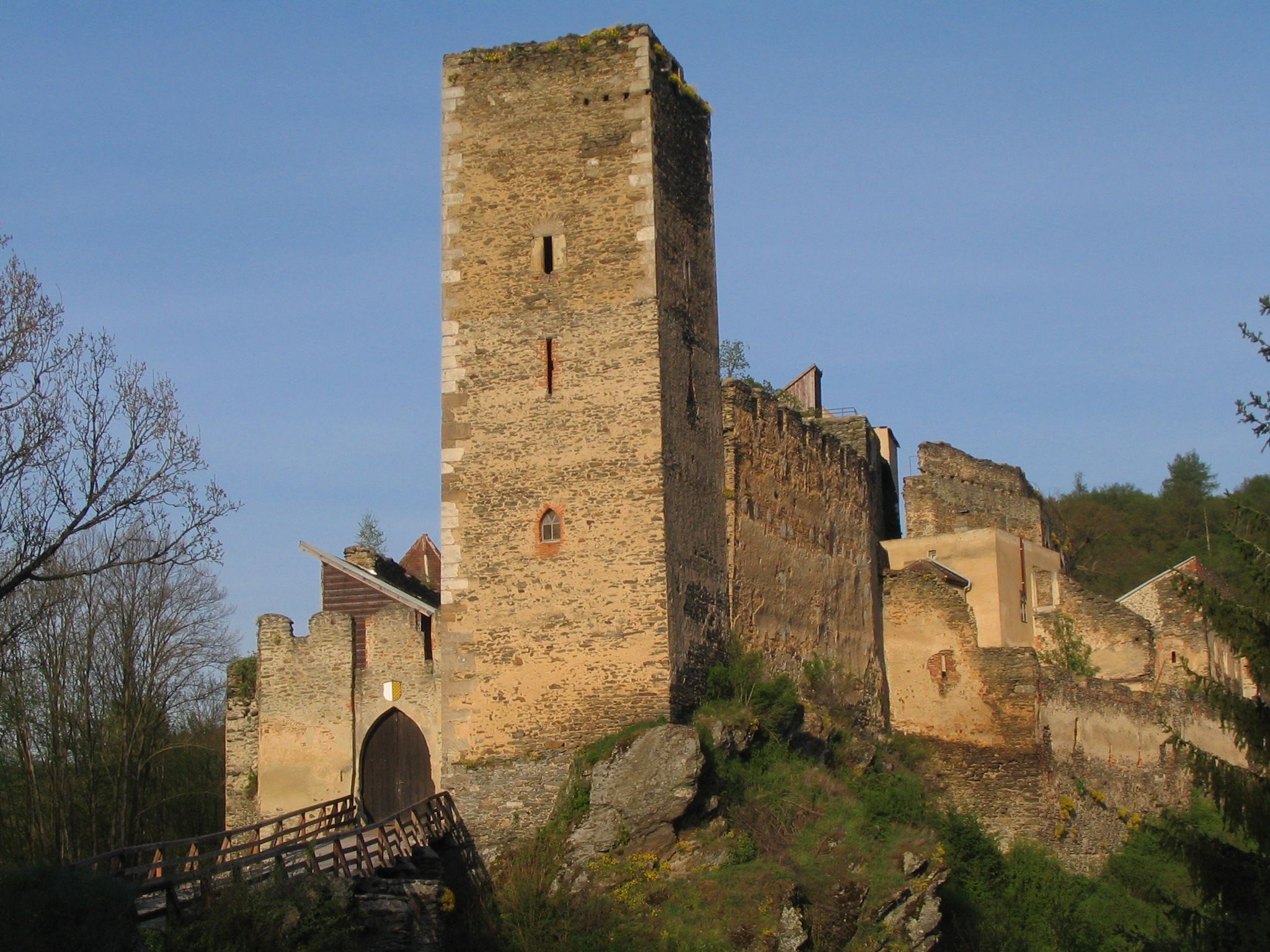 Ruins of Kaja Castle with a high tower and a bridge in the foreground.