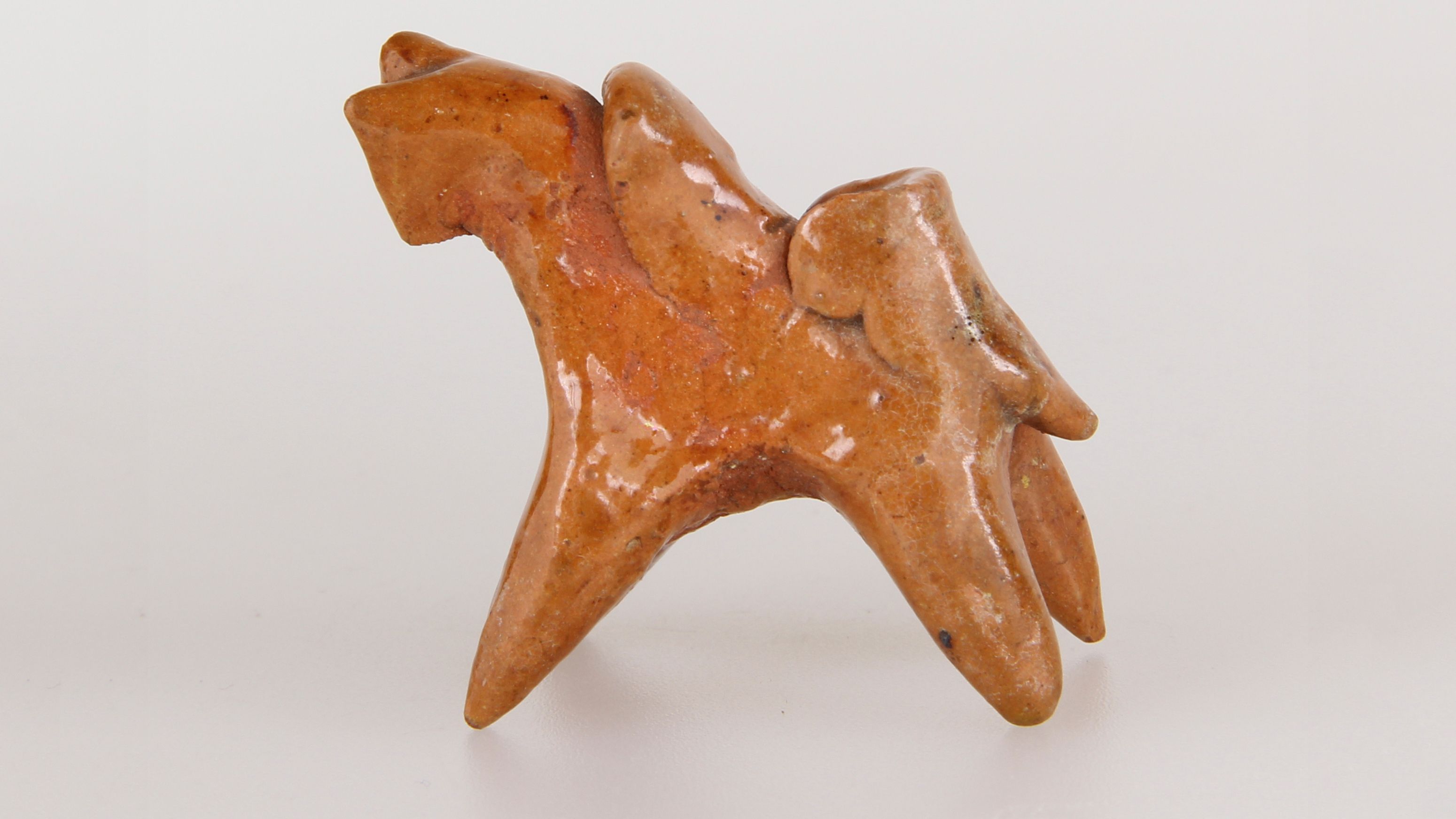 Ceramic figure of a stylized horse with rider.