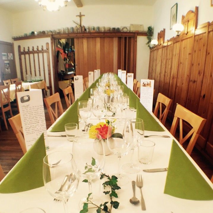 Long, festively laid table in a rustic dining room with wooden walls and decorations.