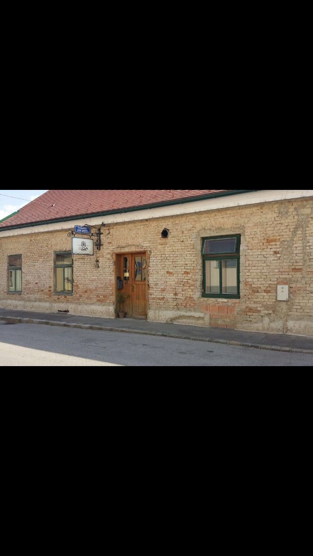 Exterior view of an old inn with tiled roof and brick façade.