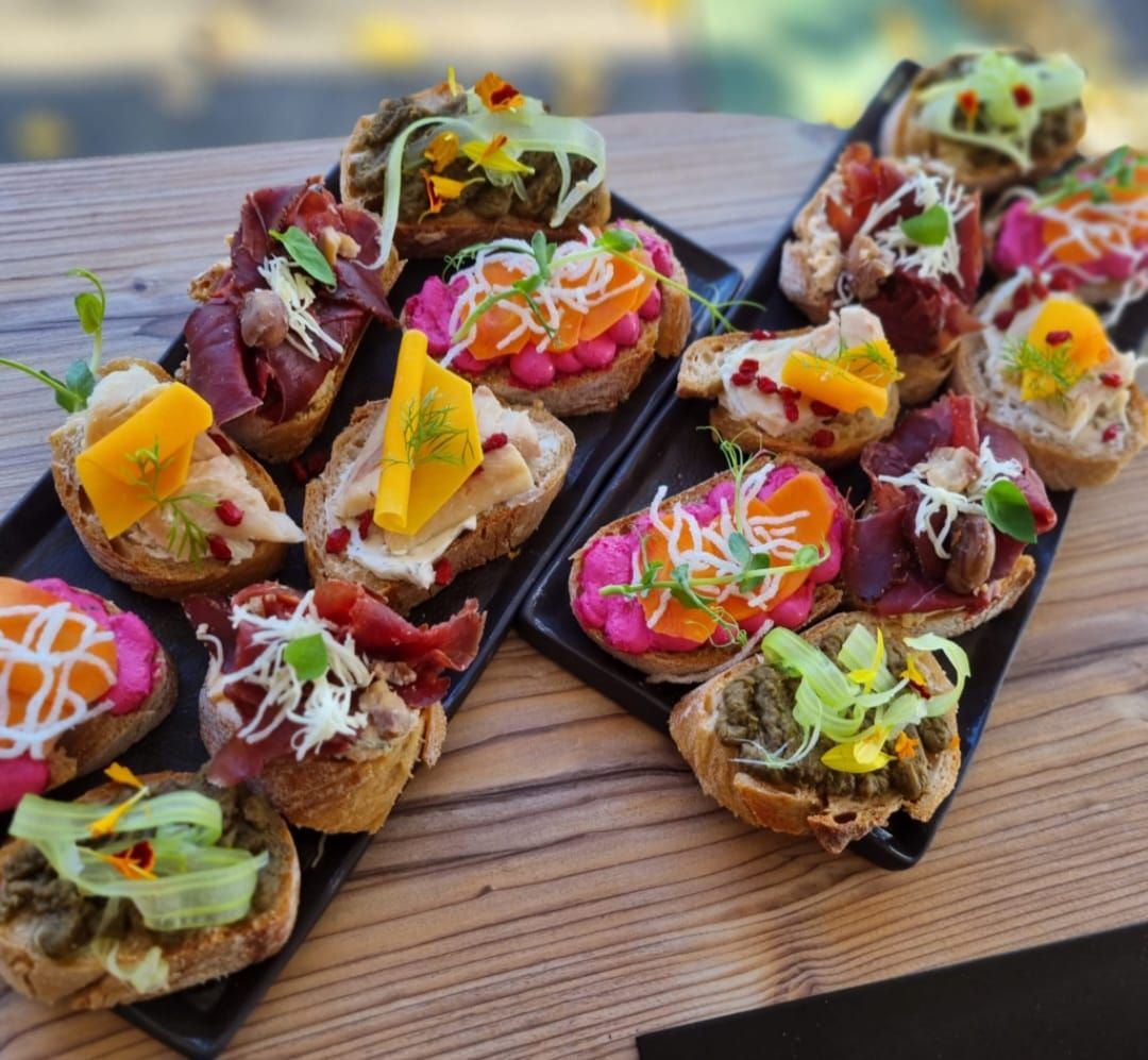 Various sandwiches on two black plates.