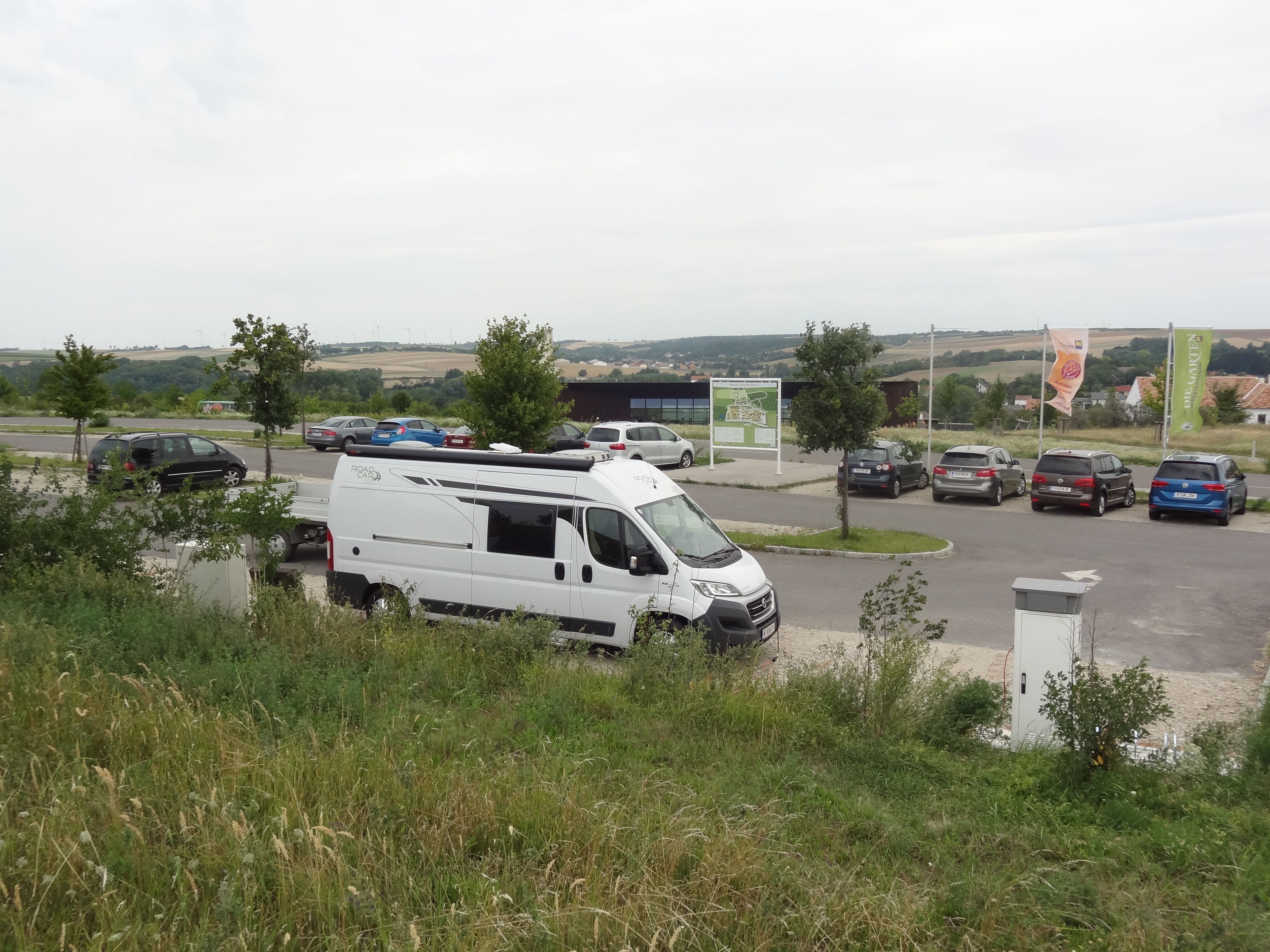 Motorhome in a parking lot with surrounding landscape.