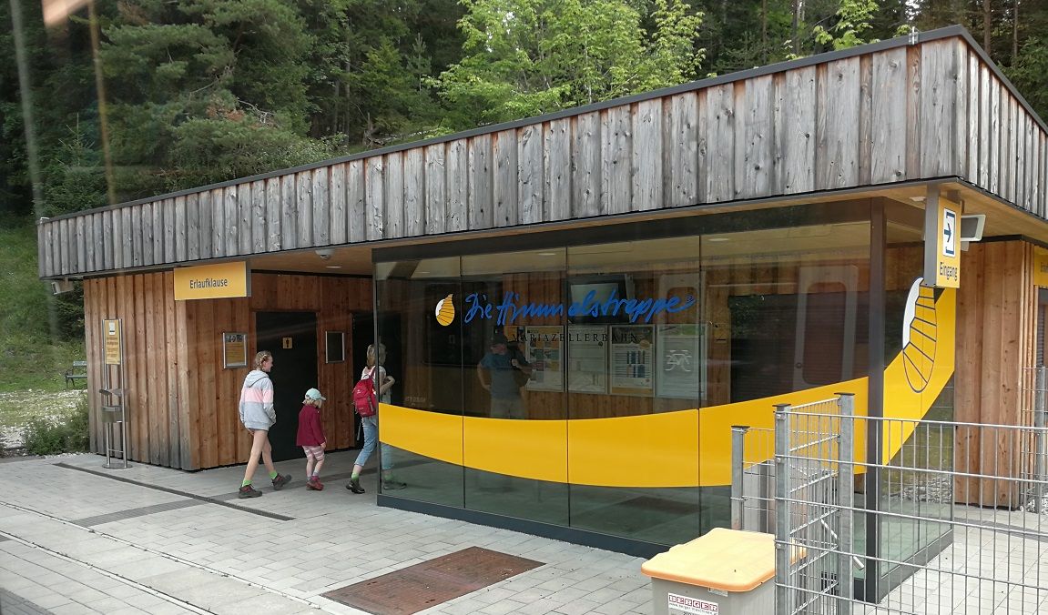 Erlaufklause station with wooden façade and glass front, people entering the building.