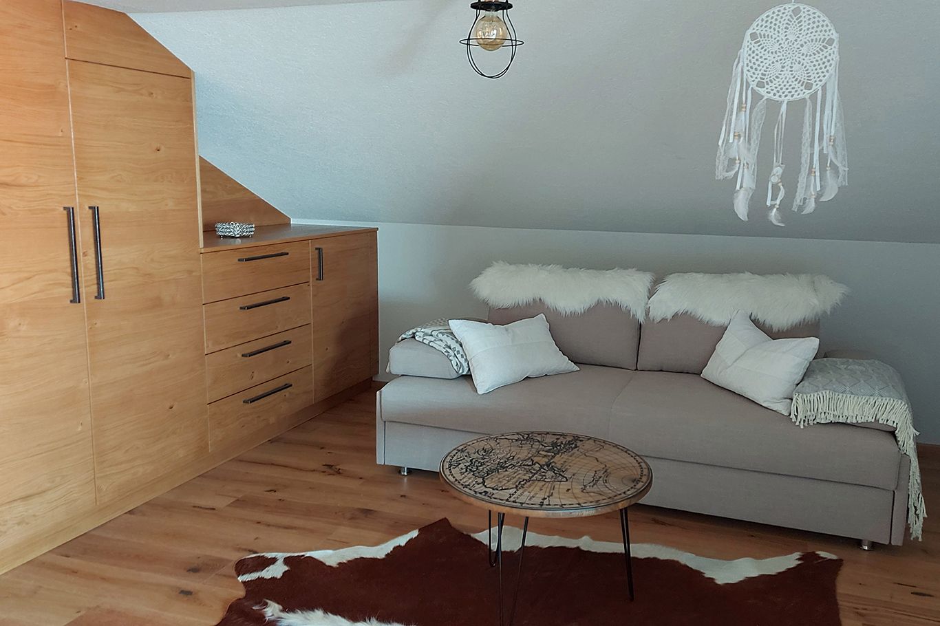 Cozy room with pull-out couch, wooden furniture and dream catcher.