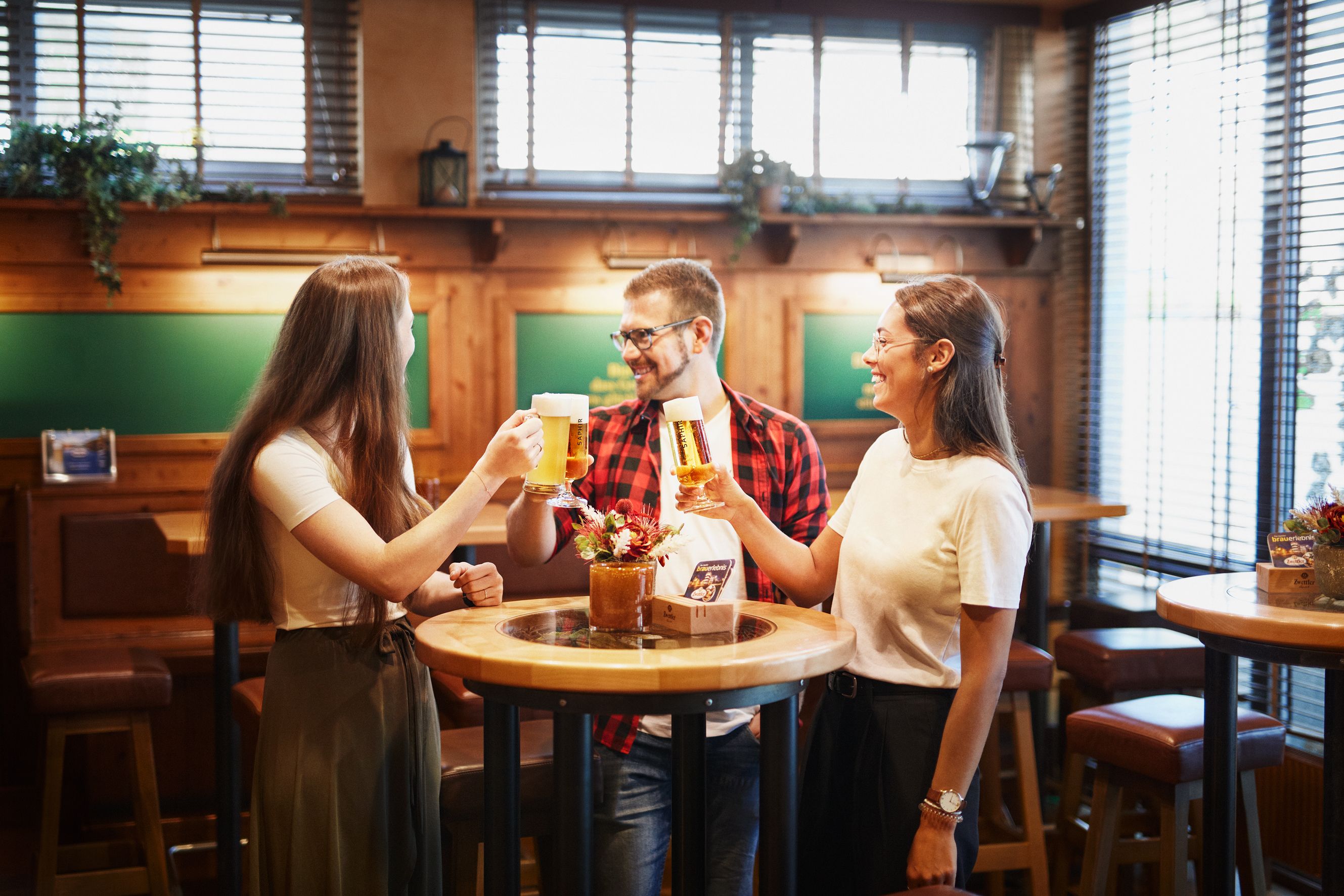 Three people clink glasses in the Zwickel parlor.