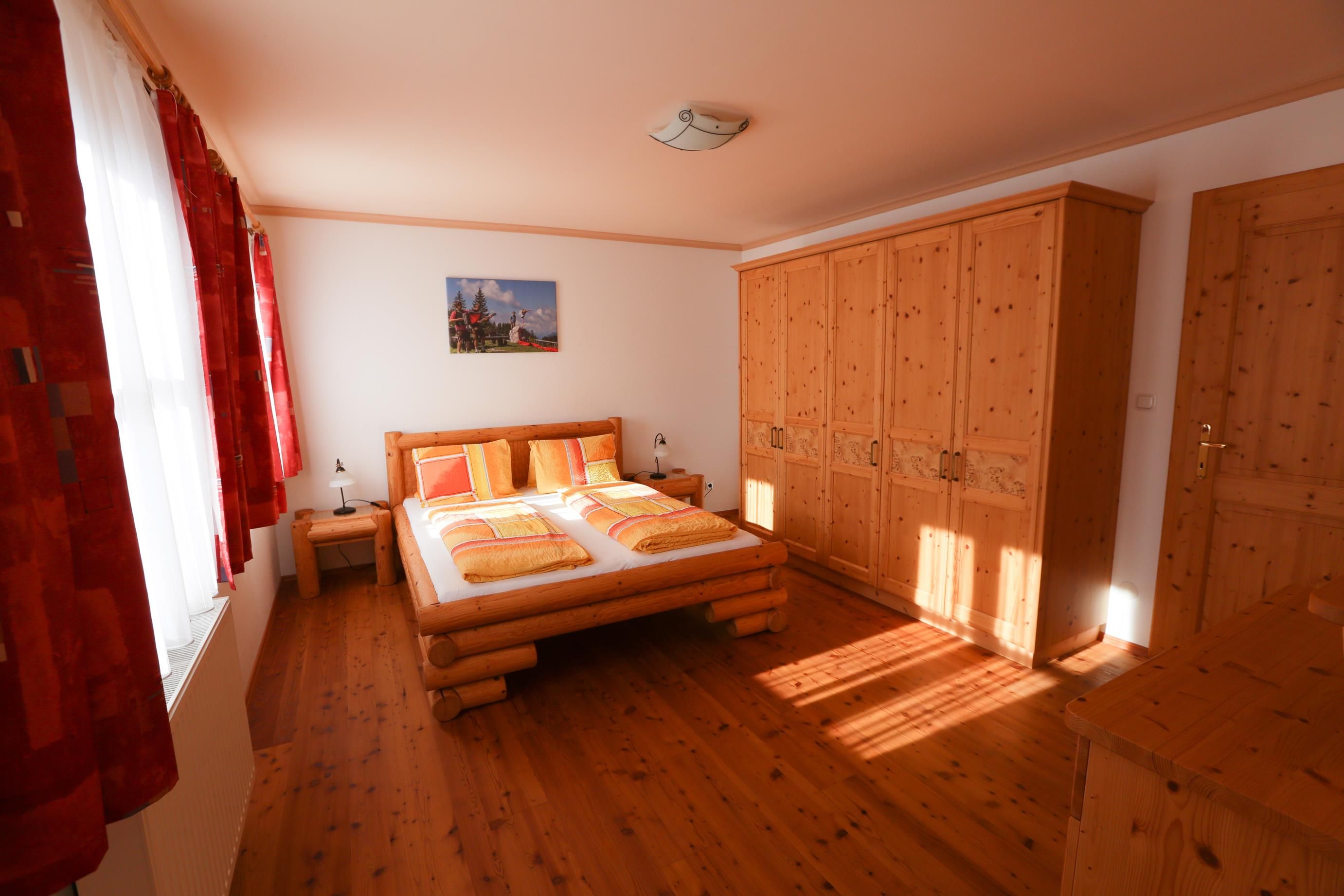 Bedroom with wooden furniture, double bed and closet.
