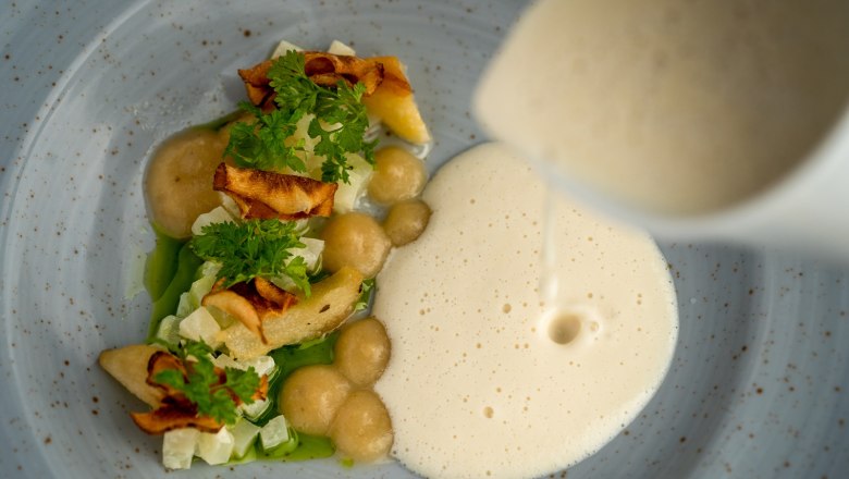 Gourmet dish with foam and vegetables on a plate.