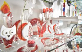 Glass decorations in red and white on a shelf.