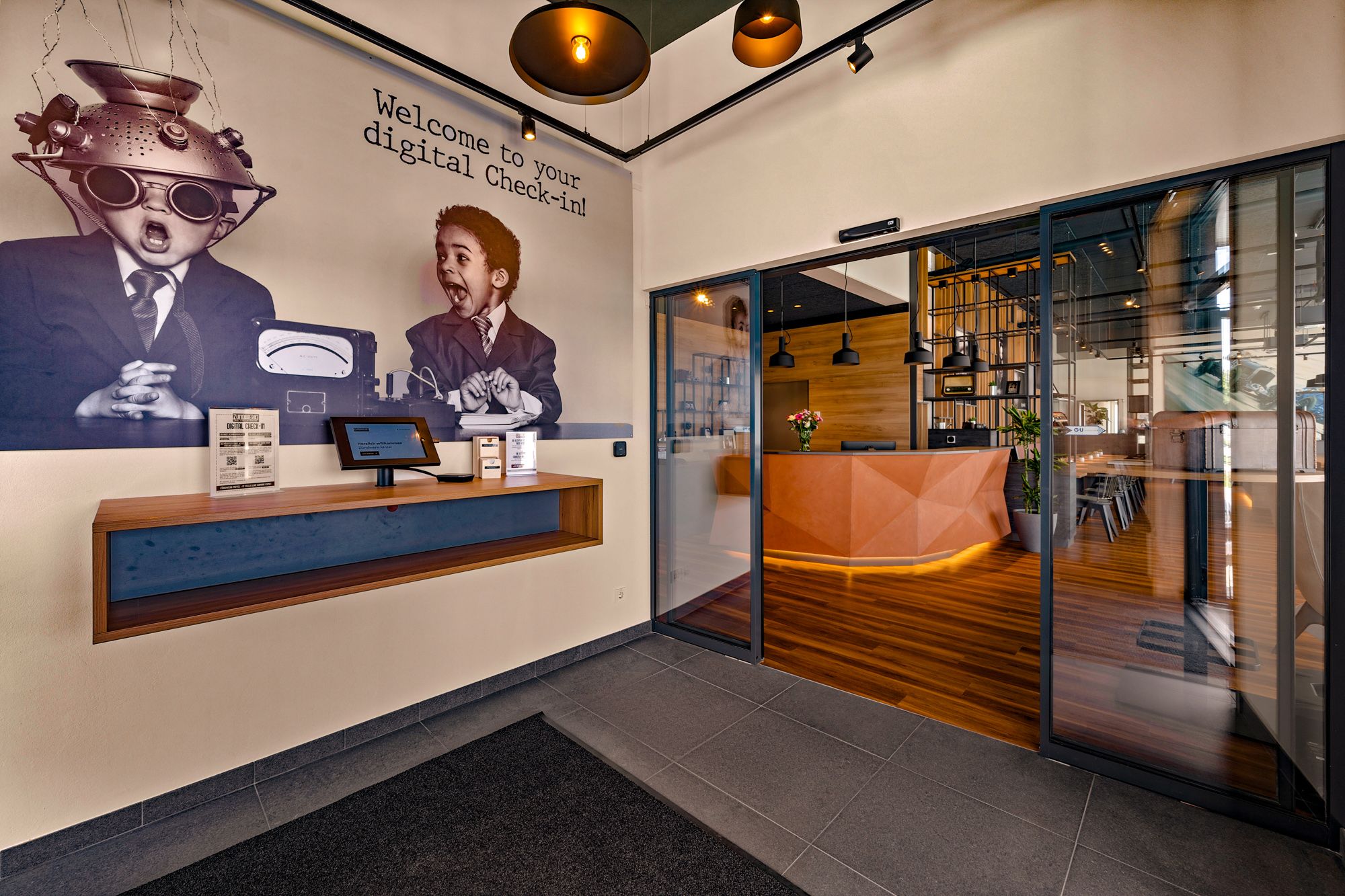 Entrance area of a modern motel with digital check-in and stylish reception area.
