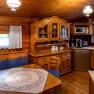 Cozy wooden kitchen with dining area, blue upholstery and tablecloth. Rustic furniture, dishwasher, microwave and coffee machine available.