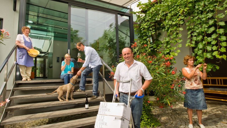 People in front of a modern building with vines and a dog.